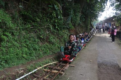 Keceriaan Satgas TMMD Bersama Warga Nikmati Wahana Lolorian di Sela Istirahat Siang